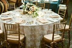 an image of a table set up for a wedding reception with white linens and gold chairs