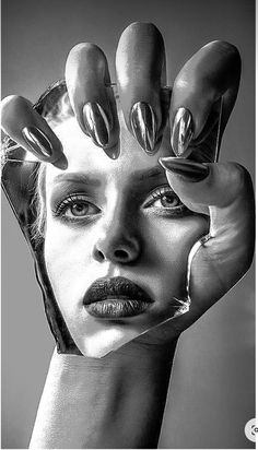 a black and white photo of a woman's face with nails on her hands