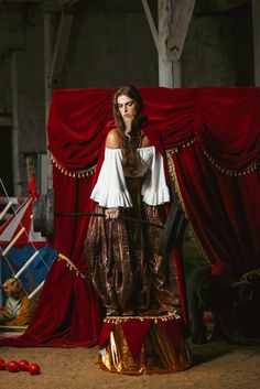 a woman standing in front of a red curtain