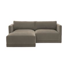 a large gray couch sitting on top of a white floor next to a small ottoman