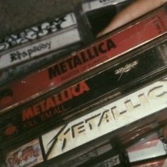 a pile of cassettes sitting on top of each other in front of a person's hand