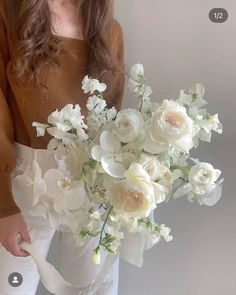 a woman holding a bouquet of white flowers