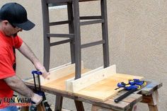 a man working on a chair made out of wooden planks with tools in front of him