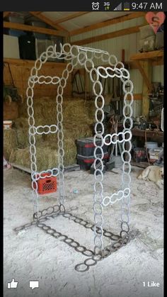 two large metal objects sitting in the middle of a room with hay bales behind them