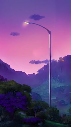 a street light in the middle of a lush green field with purple mountains behind it