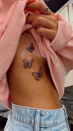 a woman's stomach with three butterflies on her side and the bottom part of her belly