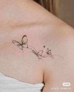 a woman's chest with three butterflies on the left side of her breast,