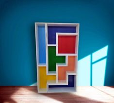 a multicolored box sitting on top of a wooden table next to a window