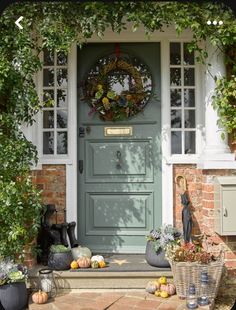 the front door is decorated with pumpkins and gourds