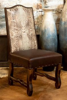 a brown leather chair sitting next to two vases