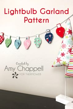 a christmas tree made out of fabric hanging from a clothes line with the words, lightbulb garland pattern