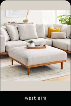 a living room with a couch, ottoman and coffee table