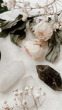 various crystals and flowers on a white cloth