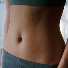 a close up of a person's stomach with no shirt and gray shorts on