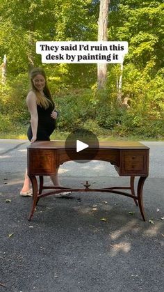 a woman standing in front of a desk with the words they said i'd run this desk by painting it