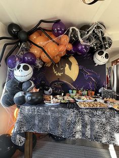 a table covered in balloons and halloween decorations