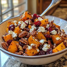 a bowl filled with fruit and nuts on top of a counter