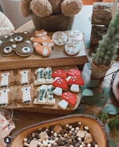 a table topped with lots of different types of cookies and pastries next to a teddy bear