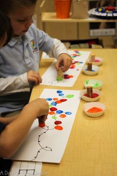 two children are doing arts and crafts on the same sheet of paper that they made