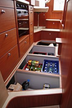 an open drawer in the middle of a kitchen with lots of items inside and out