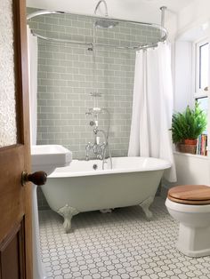 a white bath tub sitting next to a toilet in a bathroom