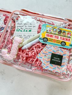 a pink plastic container filled with lots of school supplies and writing on the inside of it