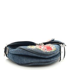 This is an authentic CHRISTIAN DIOR Denim Crystal Floral Embroidered Saddle Bag in Multicolor. The unique detailing and refined quality of this Dior saddle bag is beautifully crafted of black bright floral print canvas. The bag has a black patent leather strap with decorative silver Dior initials links. The flap opens to a black Dior name logo jacquard weave fabric with a zipper pocket. Denim Crystal, Dior Denim, Dior Saddle, Weave Fabric, Name Logo, Saddle Bag, Jacquard Weave, Black Patent Leather, Dior Saddle Bag