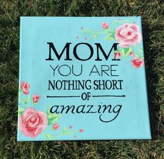 a painted sign that says mom you are nothing short of amazing on the grass with pink flowers