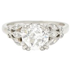 an antique style diamond ring with leaves on the sides and a center stone in the middle