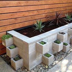 an outdoor garden with concrete blocks and plants