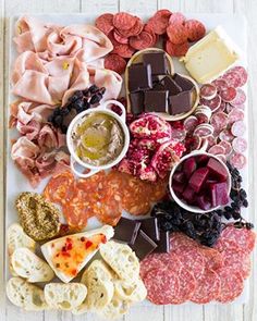 an assortment of meats and cheeses on a platter