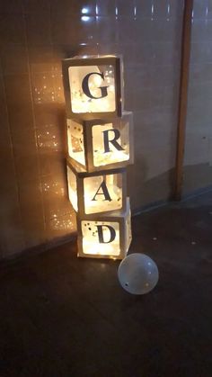 lighted blocks spelling out the word grad in front of a wall with lights on it