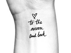 a hand that has the words to the moon and back written in black ink on it