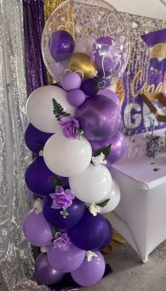 Balloon column, flowers, graduation Graduation Purple Theme, Balloon Columns With Flowers, Purple Balloon Columns, Butterfly Balloon Column, Purple Graduation Party Ideas, Purple And Gold Party Decorations, Balloon Centerpieces Diy, Balloons Centerpieces