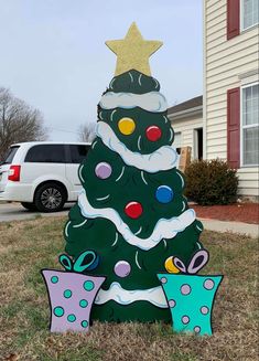 a christmas tree with presents in front of a house