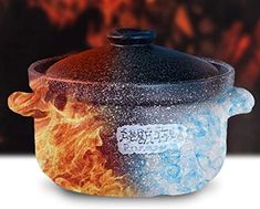 a pot with flames on it sitting in front of a wall