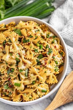 a white bowl filled with pasta and vegetables