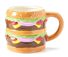 a ceramic coffee mug with a large hamburger on it's front and bottom part