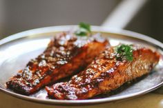 two pieces of meat sitting on top of a plate