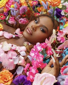 a beautiful woman laying in flowers with her eyes closed and looking at the camera,