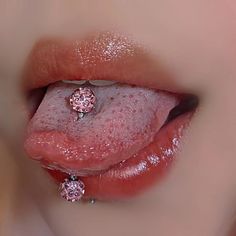 a close up of a person's tongue with a pink diamond ring on it