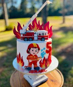 a birthday cake with a fireman on top and flames coming out of the back