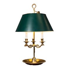 a brass plated table lamp with a green lampshade on the top and bottom