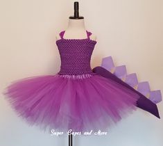 a dress made out of purple tulle and bows on a mannequin dummy