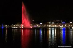 a large fountain spewing water into the night sky over a body of water