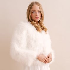 a woman in a white dress is wearing a fur stole with her hands on her hips