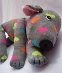 a gray stuffed animal with multicolored spots on it's legs and nose