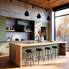 a kitchen island with stools next to it in front of large windows and wooden flooring