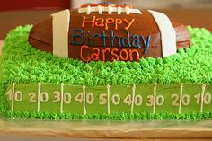 a birthday cake for a football player with green frosting and grass on the bottom