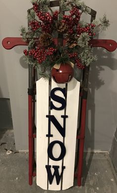 a wooden sign with the word snow written on it next to a potted plant